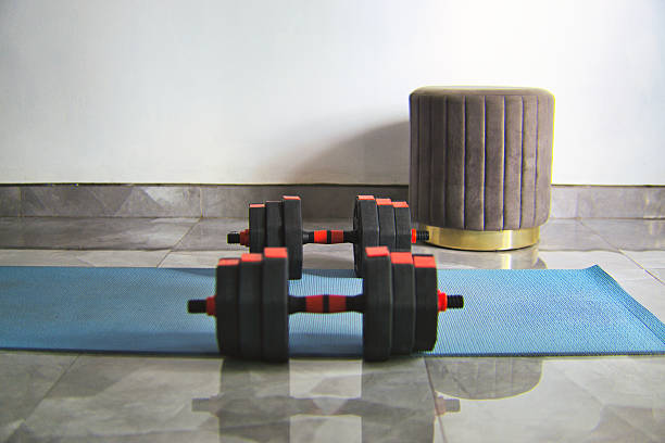 istock Fitness Equipment with Dumbbells and Mat in a Home Workout Setting 2219915169