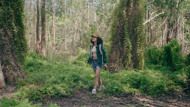 istock young women trekking in the forest 2219915742