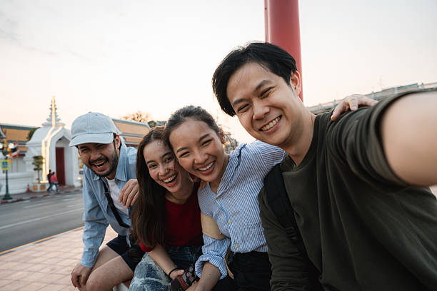 istock Group of friends taking pictures and filming themselves with digital camera while exploring the city of Bangkok 2219916175