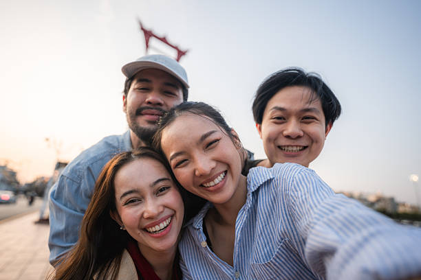 istock Group of friends taking pictures and filming themselves with digital camera while exploring the city of Bangkok 2219916211