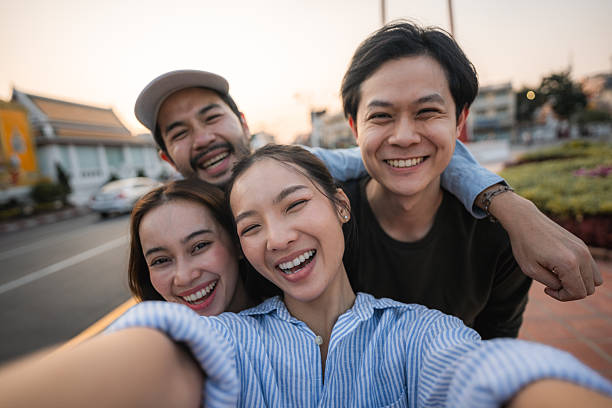 istock Group of friends taking pictures and filming themselves with digital camera while exploring the city of Bangkok 2219916229