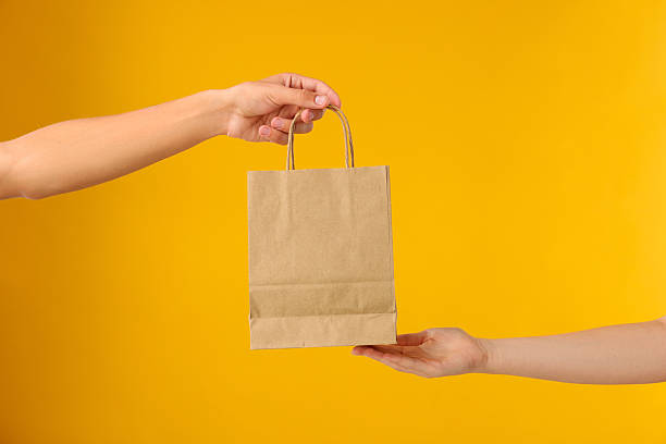 istock Fast-food worker giving customer's order on orange background, closeup 2219917210