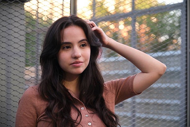 istock Young woman adjusting her hair while posing in an urban setting 2219917230