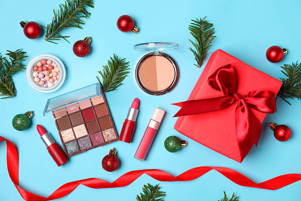 istock Flat lay composition with makeup products and Christmas decor on light blue background 2219919034