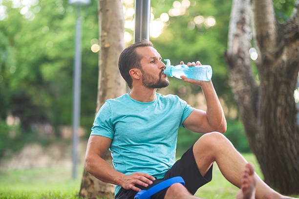 istock Sportsman taking break during workout drinking water bottle 2219919623