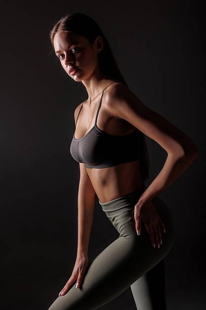 istock Model poses confidently in athletic wear against dramatic dark background during studio shoot 2219927923