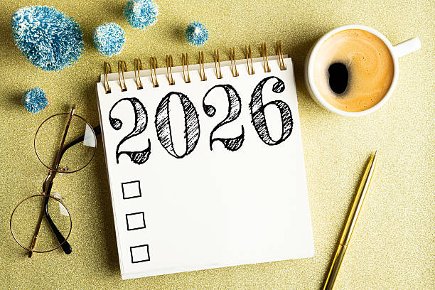 istock 2026 New year resolutions on desk. 2026 goals list with notebook, coffee cup, festive decorations on golden background. Resolutions, plan, goals, checklist, idea concept. New Year 2026 resolutions 2219928930