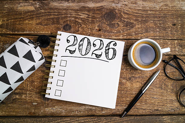 istock New year resolutions 2026 on desk. 2026 goals list with notebook, coffee cup on wooden table. Resolutions, plan, goals, action, checklist, idea concept. New Year 2026 resolutions 2219929083