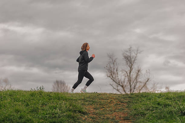 istock Woman running in a park on cloudy day 2219929231