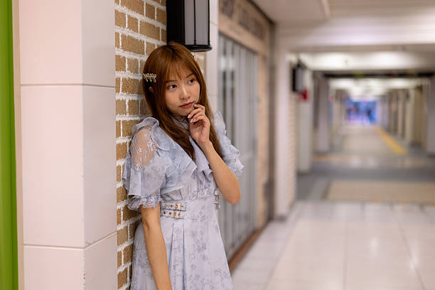 Young woman leaning on wall in shopping arcade
