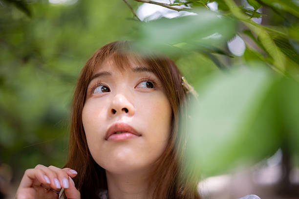 istock Young woman looking up in forest 2219939074