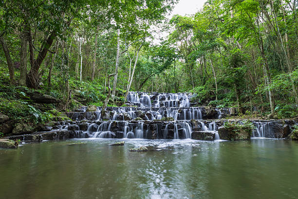 istock Samlan Waterfall, tier 1, serene tiered waterfall in tropical forest with lush green trees and clear water. 2219939728