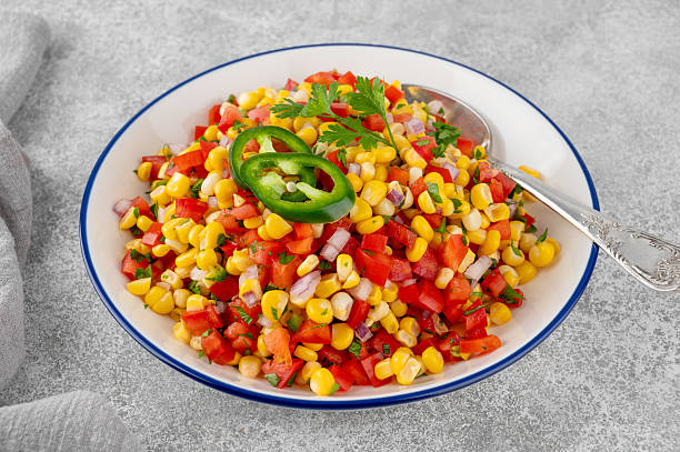 istock Corn salsa in a bowl with lime, jalapeno pepper, fresh herbs and tortilla chips on a concrete background. Mexican cuisine. Healthy food. 2219940021