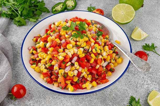 istock Corn salsa in a bowl with lime, jalapeno pepper, fresh herbs and tortilla chips on a concrete background. Mexican cuisine. Healthy food. 2219940035