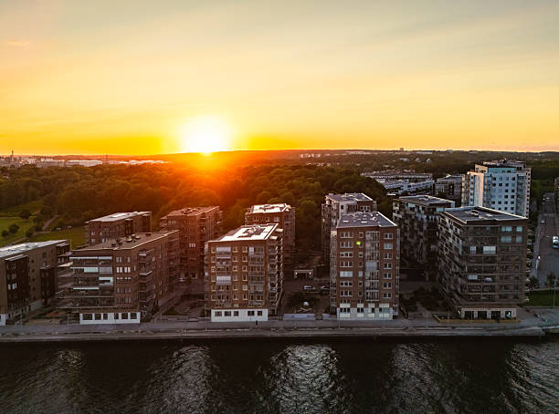 Gothenburg's modern waterfront buildings bask in the golden glow of a breathtaking sunset, captured from a unique drone perspective