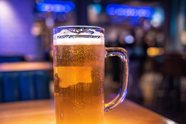 istock Refreshing pint of beer resting on table in bustling london pub 2219942490