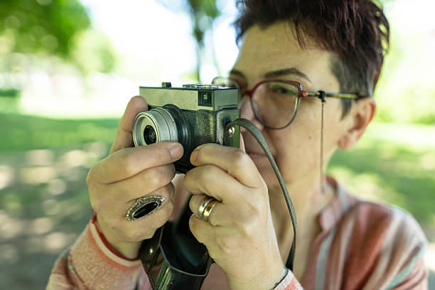 istock Happy woman adjusting her old-fashioned camera in the park. 2219943525