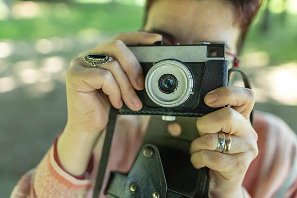 Close up photo of woman hands using old camera.