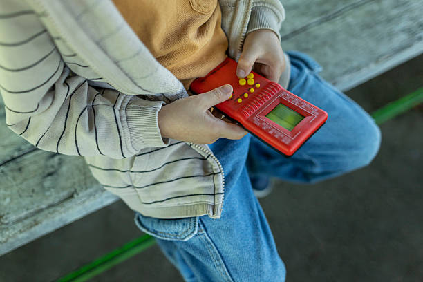 Boy sitting on a bench playing game. Close up photo