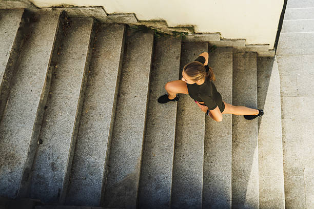 istock Female Athlete Stretching Her Legs While Walking Up The Stairs Before Training Outdoor 2219946035