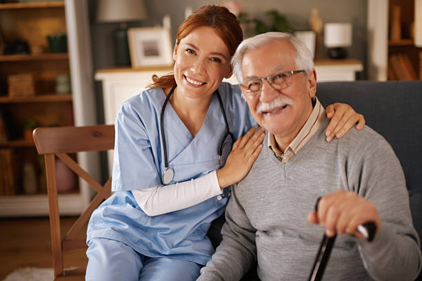 istock Nurse smiling and comforting elderly man at home 2219946323