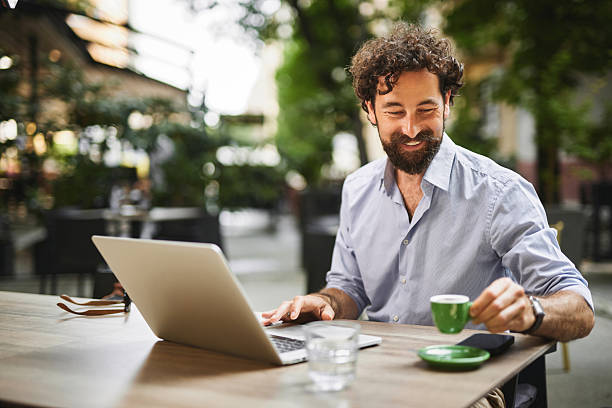istock Freelancer enjoying working at outdoor cafe with laptop and coffee 2219946517