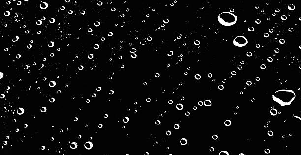 istock lose-up of white water drops floating on a black background. 2219946859