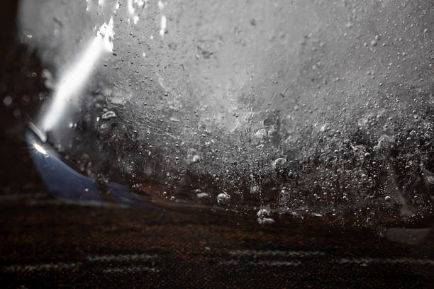 Macro shot of a block of ice with embedded air bubbles and textures, captured with dramatic lighting. The abstract composition creates a mysterious, cold, and scientific aesthetic ideal for climate, science, or winter-themed visuals.