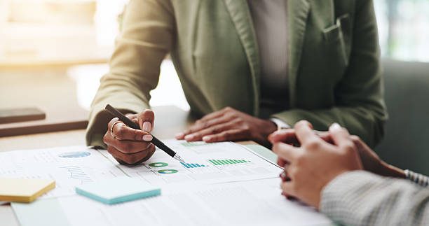 istock Hands, business people and advice with discussion, graphs and profit growth or sales analytics. Closeup, teamwork and financial advisor with proposal, feedback or ideas for charts or company revenue 2219948911