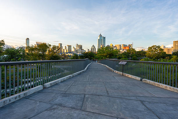 Green city park with sunset blue sky cloud pathway and beautiful trees track running  walking relax in park on green grass field on the side.