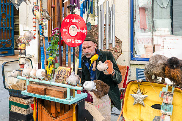 Porto, Portugal - November 2, 2024: Busker playing a card based music box with chickens and birds