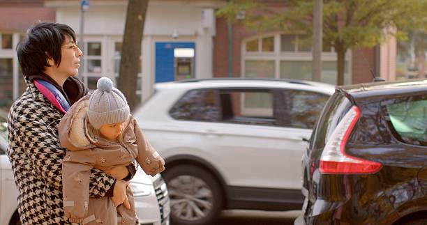 istock A Parent Holding a Child in an Urban Setting While Engaged in Daily Activities 2219955503