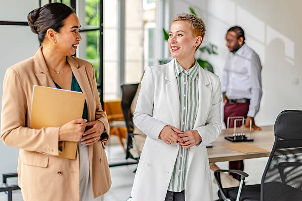 istock Two business professionals engage in conversation while another colleague works in a modern industrial office space 2219957762