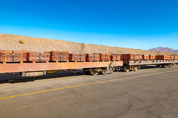 A long train carries stacks of copper cathodes through a vast mining landscape in Chile.