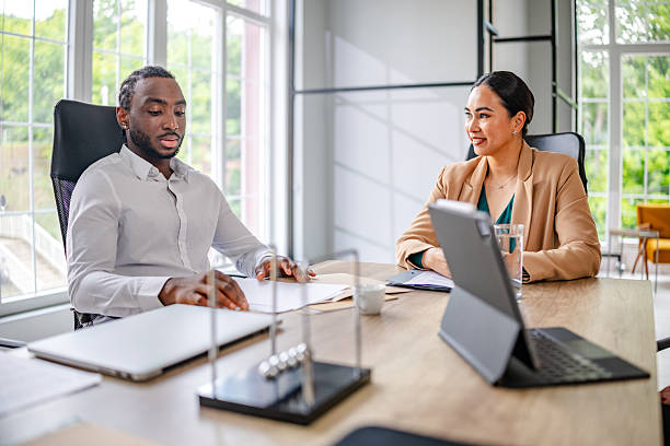 istock Engaged discussion between business professionals in a modern industrial office setting during a working meeting 2219959716