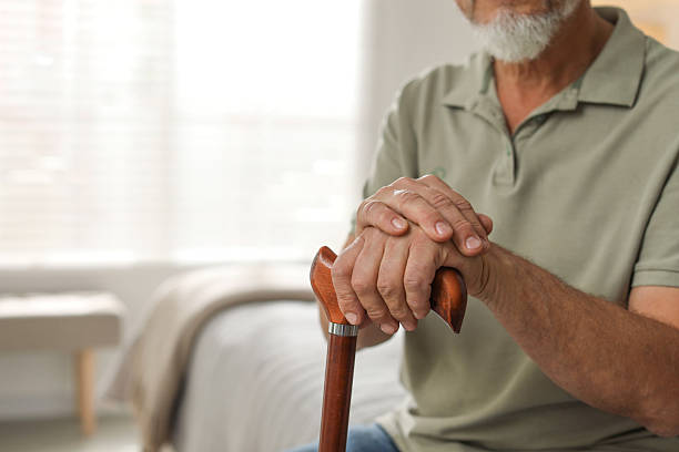 istock Lonely senior man with walking cane at home, closeup. Space for text 2219960908
