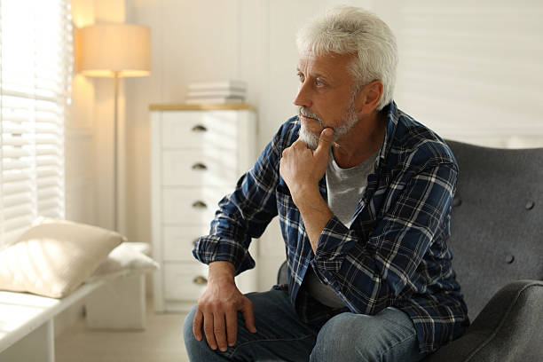 istock Lonely senior man sitting in armchair at home. Space for text 2219961042