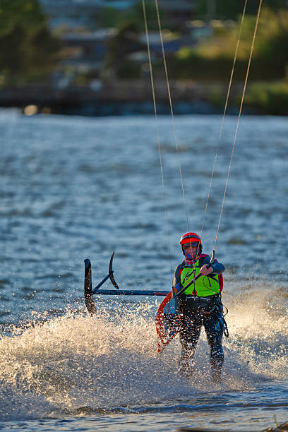 Cape Town, South Africa - March 8, 2012: A kiteboarder romps in the Atlantic Ocean off Blouberg Beach, in the northern suburbs of Cape Town. Although the sea is cold, the frequent strong winds make Blouberg a magnet for kiteboarders and sailboarders, with hundreds of kites sometimes to be seen at the same time. The ship in the background is waiting to enter the nearby port of Cape Town.