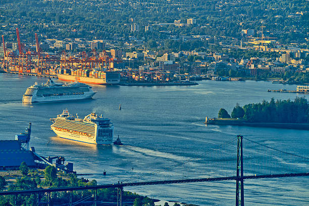 The city of Vancouver region in the province of British Columbia on June 02, 2023: Sunrise view of a cruise ship entering the Vancouver Burred Inlet Harbor while passing under the Lions Gate Bridge, British Columbia