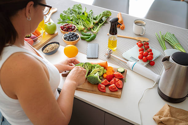 istock Chopping fresh organic vegetables, kitchen, cutting board and knife, woman's hands preparing healthy vegetarian meal at home. Dieting and wellness, lunch or dinner recipe, kitchen appliances on table 2219962358