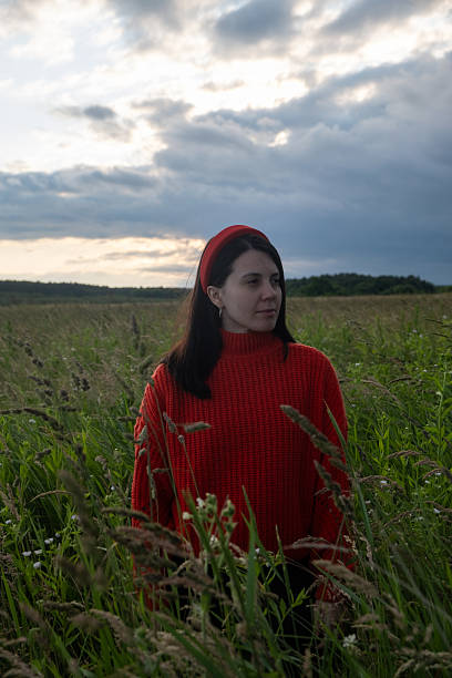istock Woman in Red Sweater in Grassy Field 2219962468
