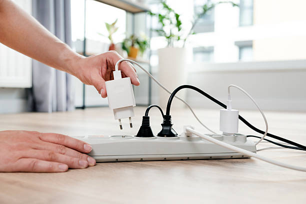 istock Person is plugging in a device to a power strip 2219963486