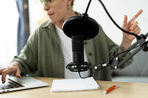 istock Podcaster recording audio content, using laptop and microphone 2219964166