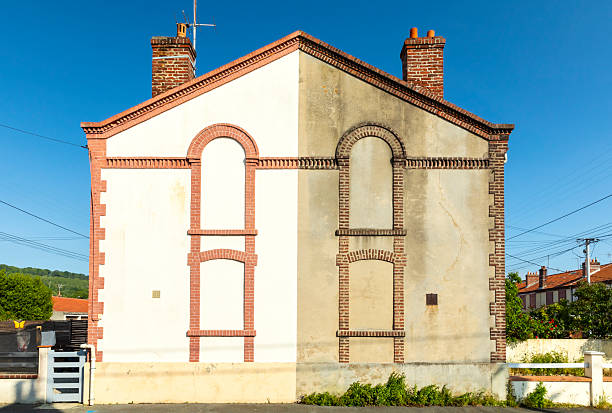 Renovated and unrenovated gable wall of a house in Northern France
