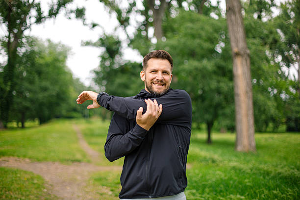 istock Young man stretching arms before running in the park 2219965569