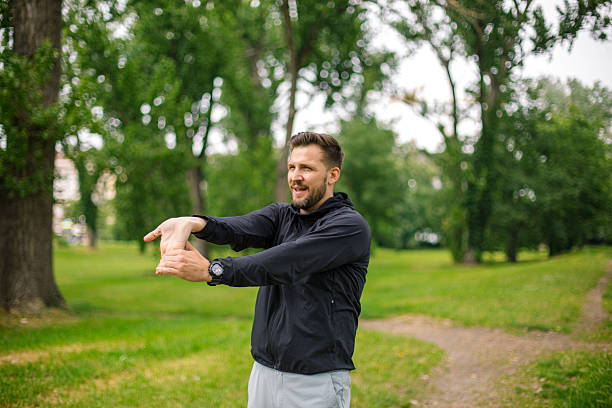 istock Man stretching arms before running in a green park 2219965653