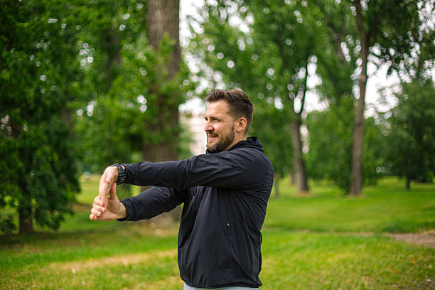 istock Sportsman stretching arms before running in the park 2219965733
