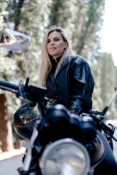 istock Young woman enjoys an adventure on her motorcycle in a serene forest setting during a sunny day 2219966480