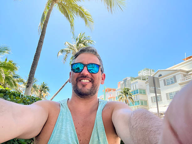istock Tourist taking a selfie in Miami Beach, Florida, under palm trees 2219967637