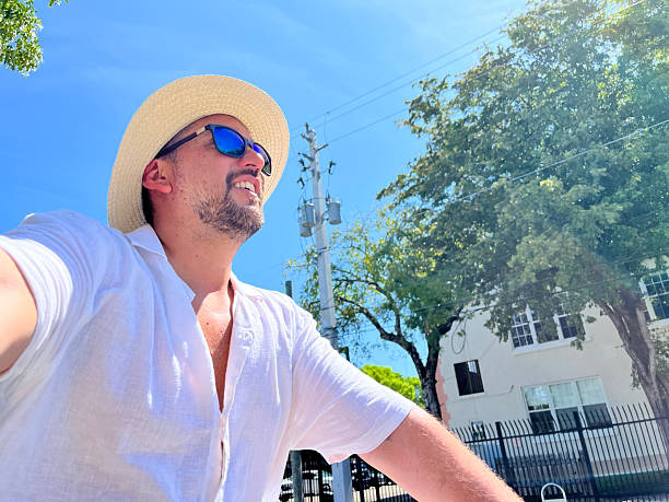 Tourist riding a bicycle and taking a selfie in Miami Beach